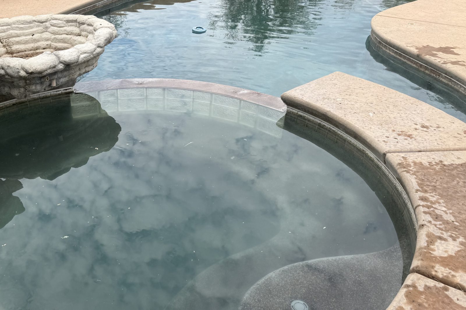 The same spa with clear water and a visible plaster floor after Providence Pool Care service