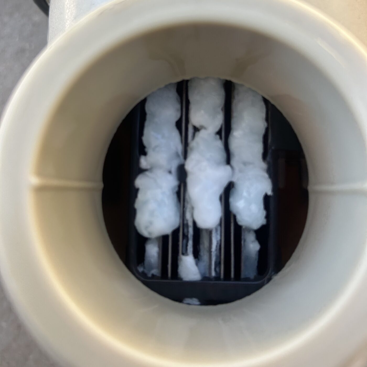 Looking down into a salt cell housing at white calcium build-up between the plates