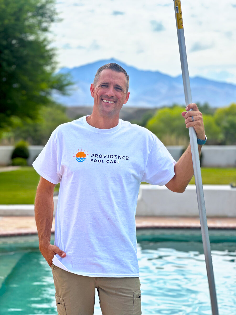 Josiah Linaman, owner of Providence Pool Care, holding a pool pole beside a backyard pool