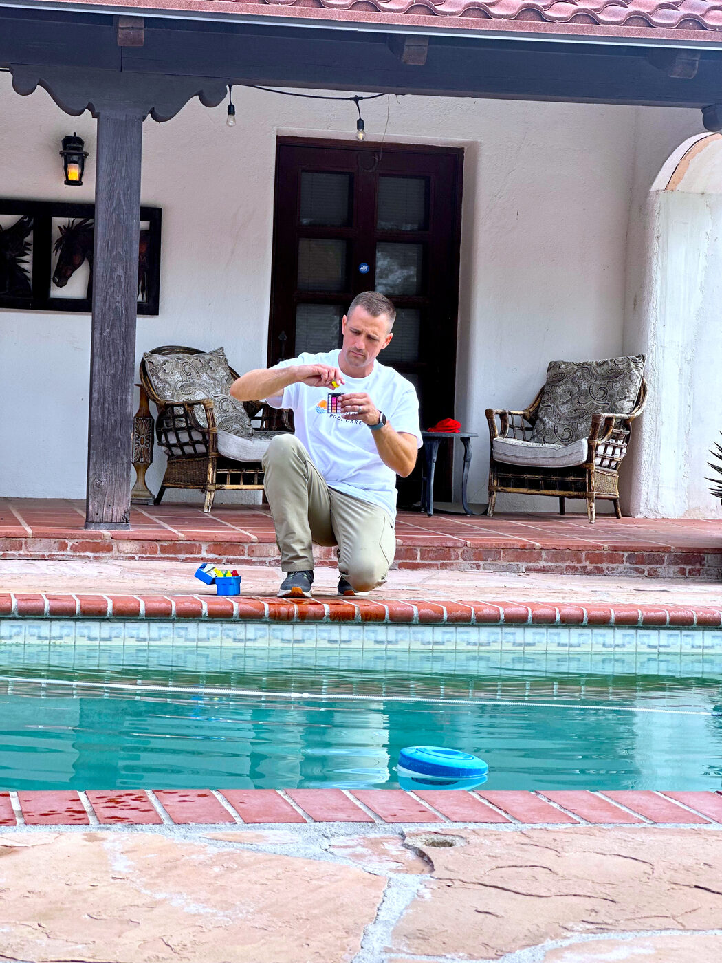 Josiah testing and balancing pool water at a backyard pool